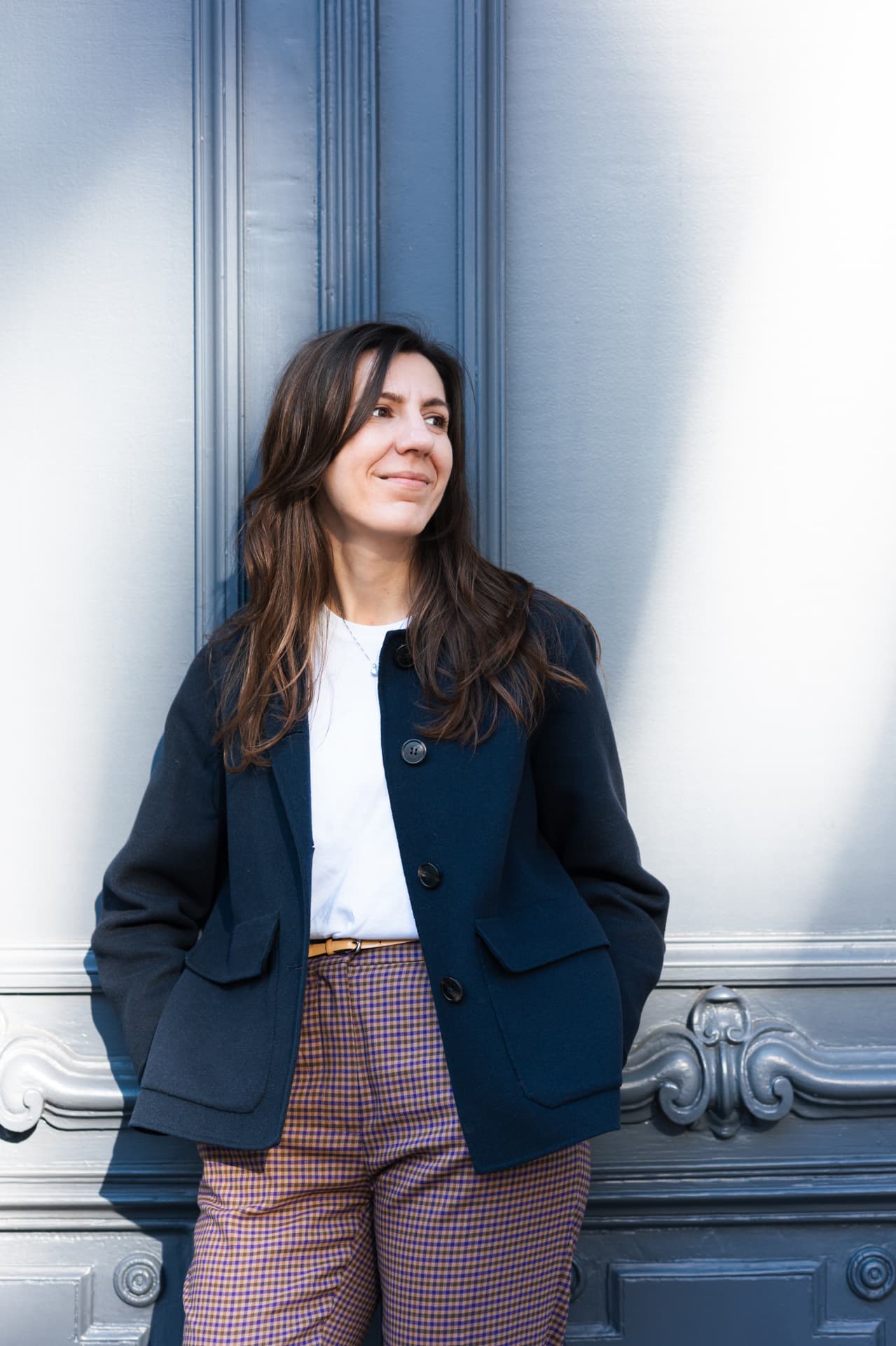 Andreea Stănescu in a navy coat in front of a blue door